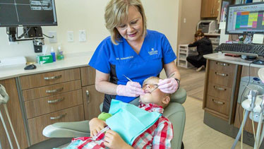 Dentist cleaning child's teeth